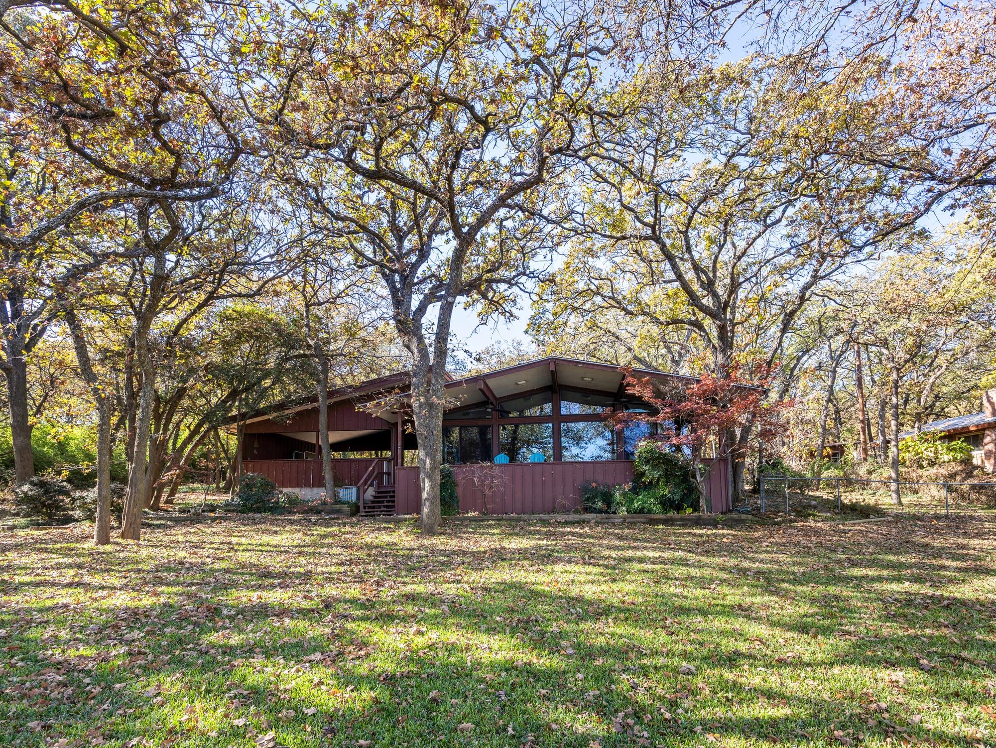 Exterior architecture of 13030 Miller Road in Azle, TX; a midcentury lake house by Al Komatsu staged by Comfort Is Created to highlight the waterfront views of Eagle Mountain Lake.
