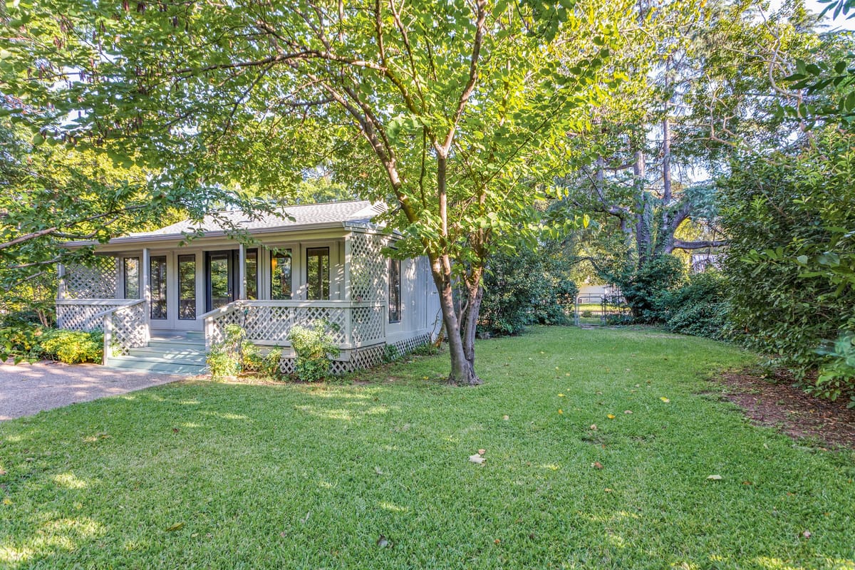 Covered porch overlooking a backyard surrounded by mature trees at 3700 Wildwood Road, a Crestwood home in Fort Worth, Texas.