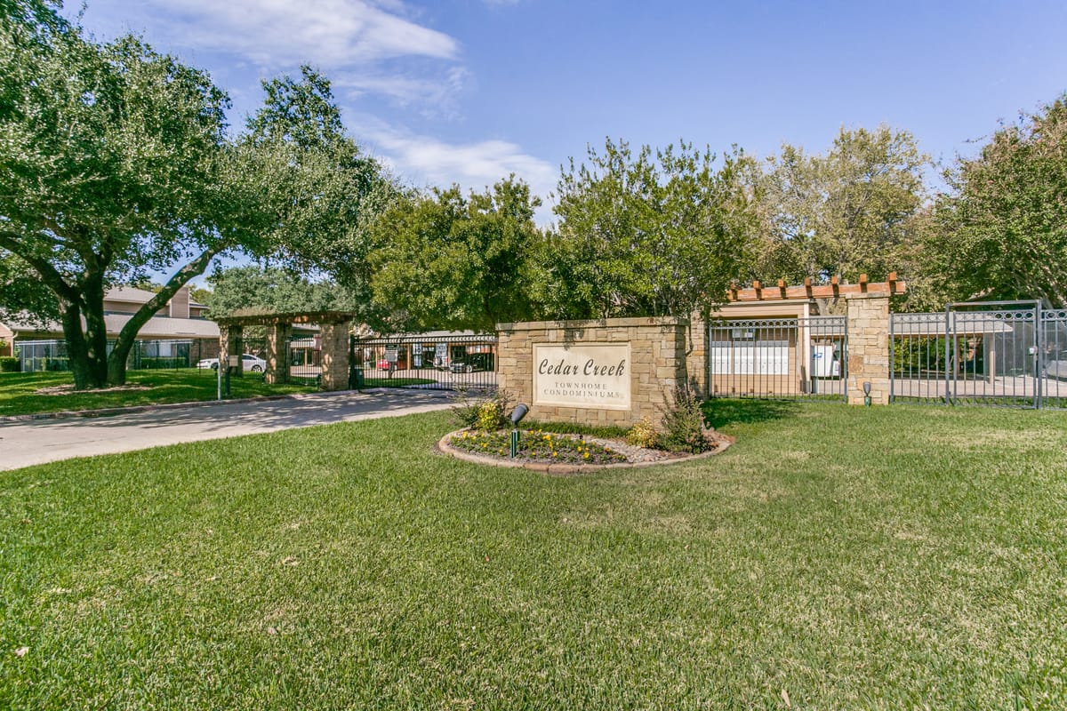 Entrance to Cedar Creek Townhomes, a gated residential townhome community in Benbrook, Texas.
