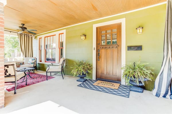 Colorful Craftsman-style home with a large front porch in the Ryan Place neighborhood of Fort Worth, Texas.
