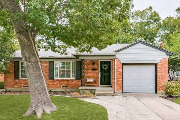 Exterior of 6126 Saint Moritz, a home in the Caruth Terrace neighborhood of Dallas, Texas, on a tree-lined street with midcentury architecture.